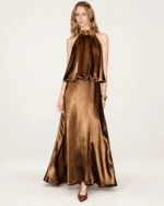 Plano frontal da modelo vestindo vestido longo em cetim bronze metalizado em estúdio mineral