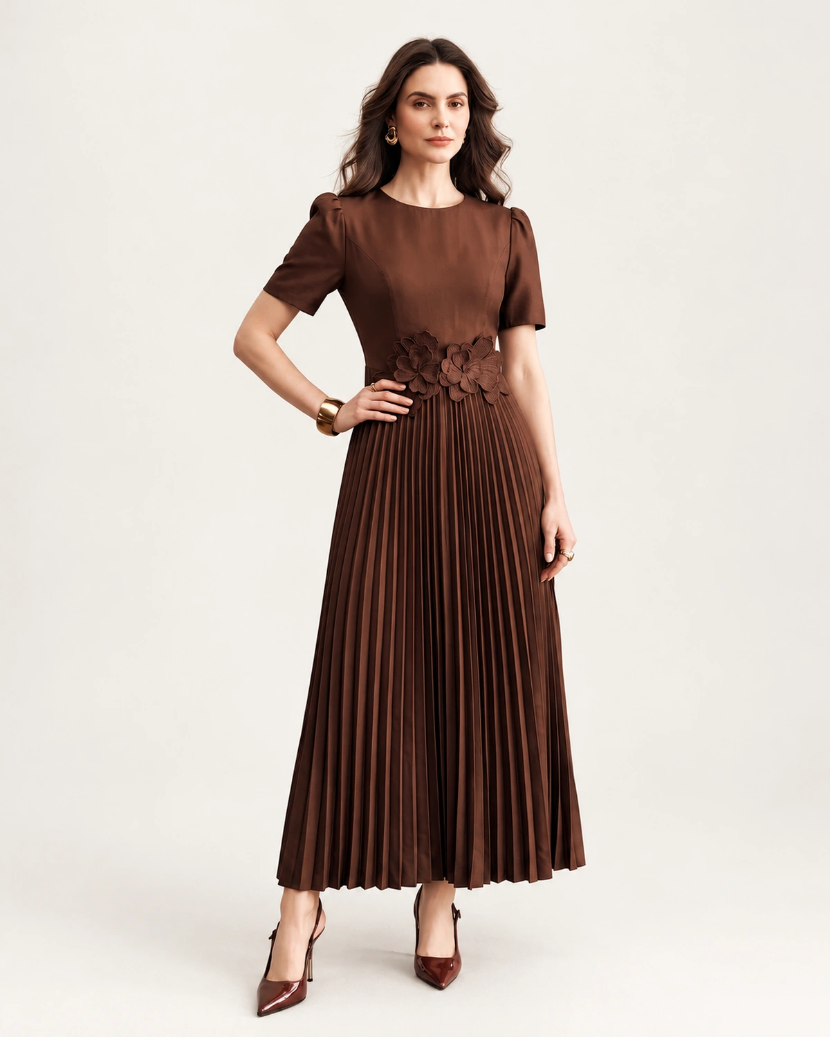 Plano médio da modelo vestindo vestido midi em crepe plissado com decote redondo e mangas curtas.