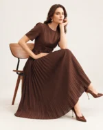 Vista de corpo inteiro da modelo exibindo as proporções e o comprimento midi do vestido marrom.