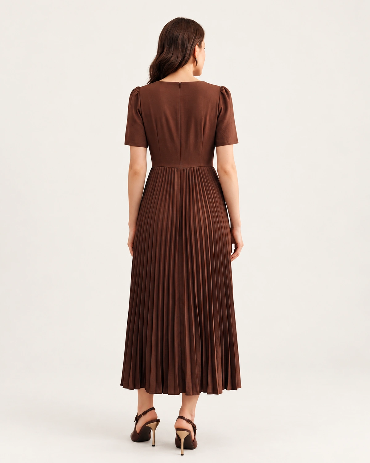 Editorial da modelo em estúdio mineral vestindo vestido midi em crepe plissado marrom.