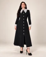 Modelo vestindo vestido midi evasê preto com gola e punhos de renda branca em estúdio mineral