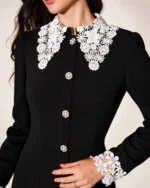 Modelo vestindo vestido midi evasê preto com gola e punhos de renda branca em estúdio mineral