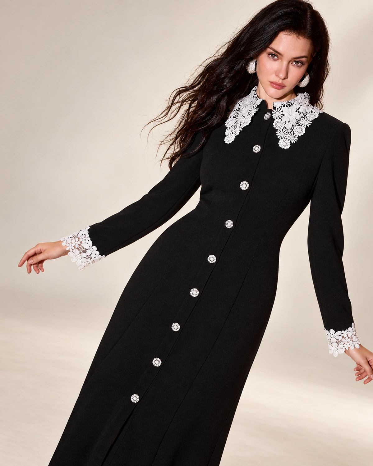 Modelo vestindo vestido midi evasê preto com gola e punhos de renda branca em estúdio mineral
