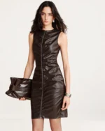 Plano médio da modelo vestindo vestido em couro marrom com clutch